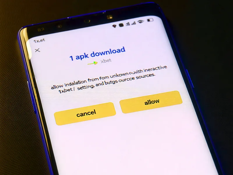 Màn hình điện thoại Android hiển thị quá trình tải xuống file 1xBet APK, với một cửa sổ bật lên yêu cầu cho phép cài đặt từ nguồn không xác định, trên nền màu xanh đậm.