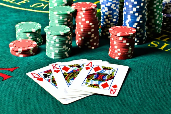 Hình ảnh một bàn poker với các lá bài, chip và người chơi đang tập trung, thể hiện sự căng thẳng và chiến thuật của các trò chơi poker tại 1xBet.